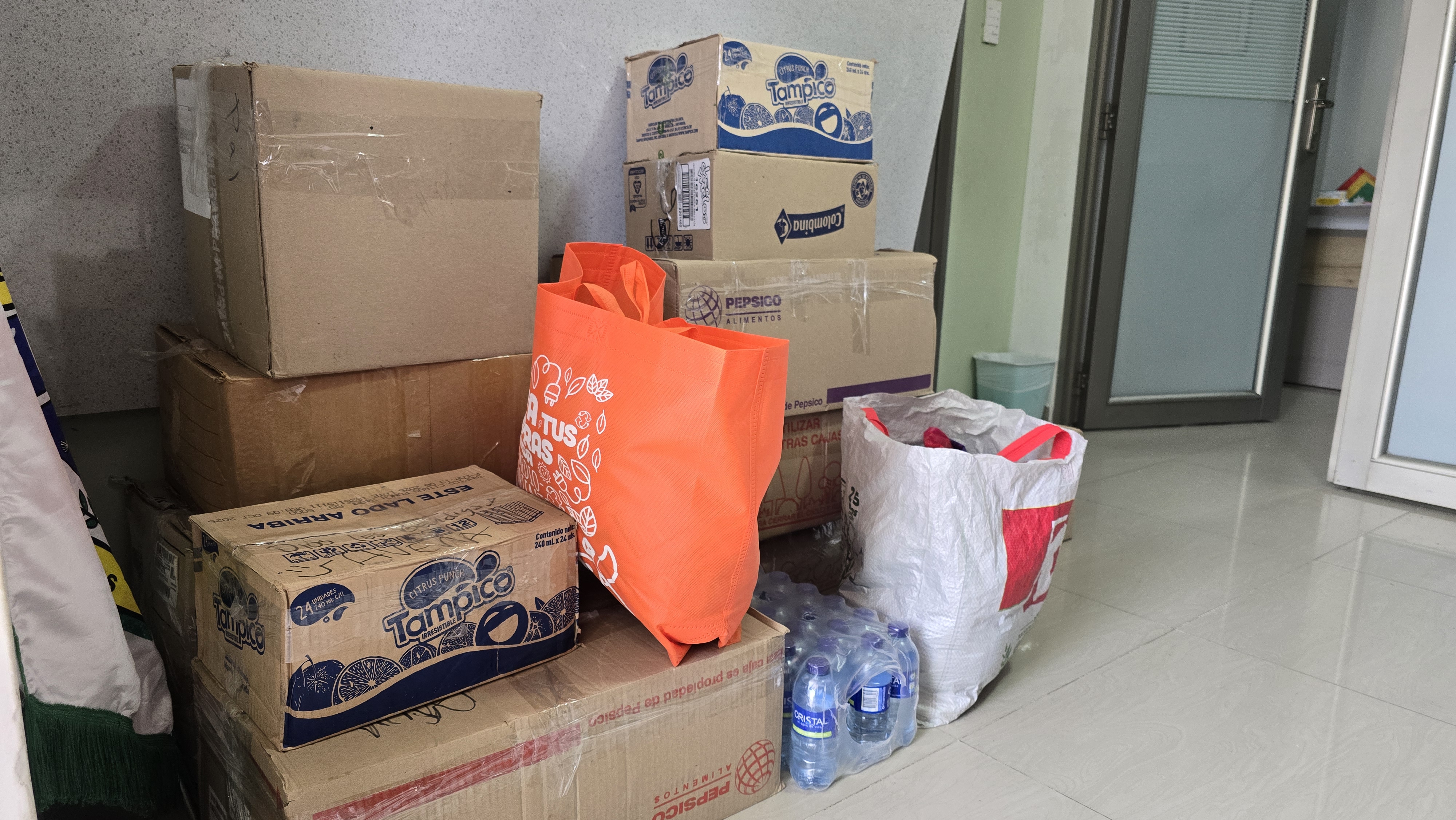 Dos representantes de FUNCEPAL posan junto a cajas con donaciones frente a un vehículo del Banco de Alimentos de Cartagena.